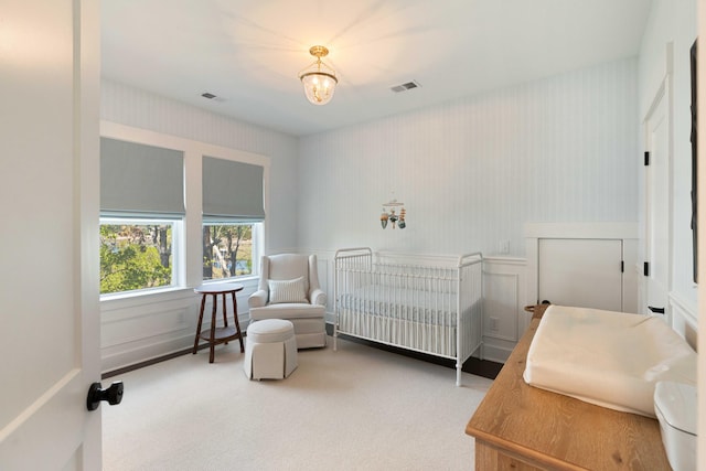 bedroom featuring wallpapered walls, visible vents, an inviting chandelier, and carpet