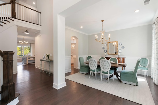 dining space featuring visible vents, arched walkways, wainscoting, wood finished floors, and a notable chandelier