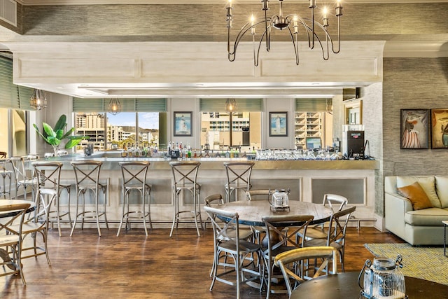 dining area with a notable chandelier, bar area, and dark hardwood / wood-style flooring