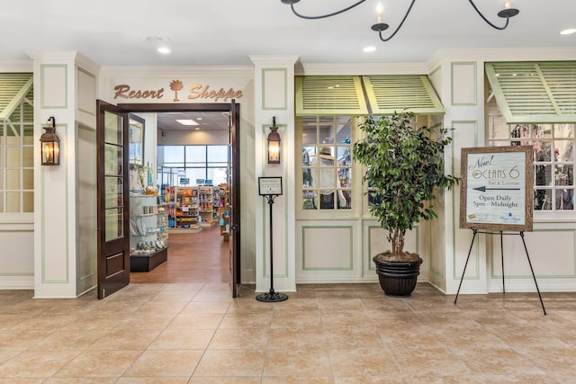 interior space with crown molding and light tile patterned flooring