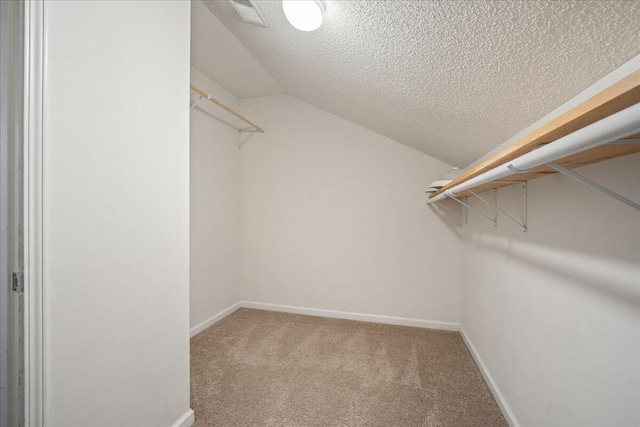 walk in closet featuring lofted ceiling and carpet floors