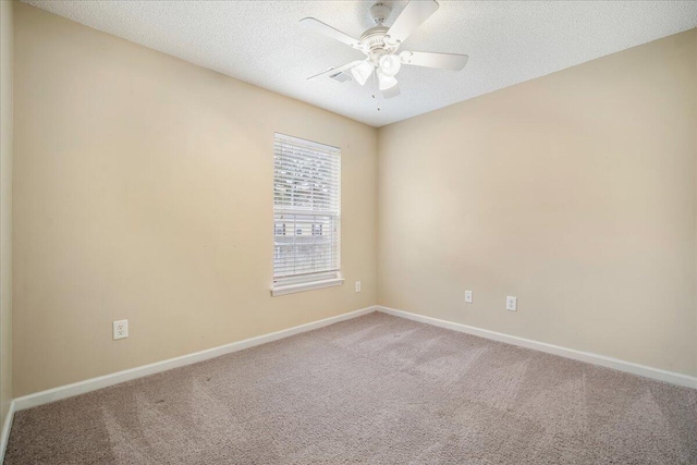 carpeted spare room with ceiling fan and a textured ceiling