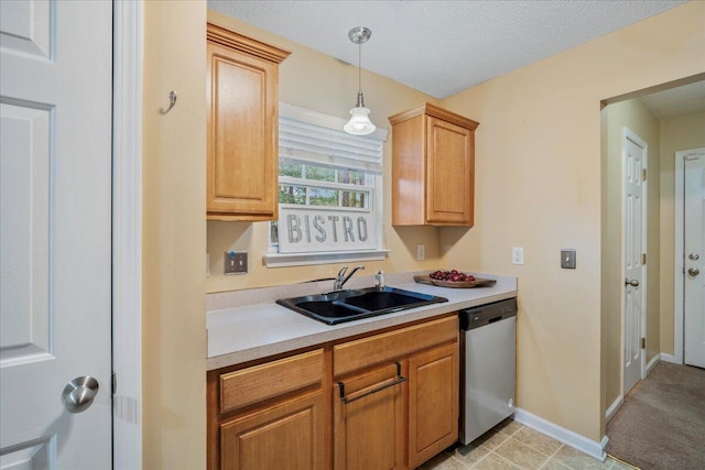 kitchen with stainless steel dishwasher, sink, hanging light fixtures, and a textured ceiling