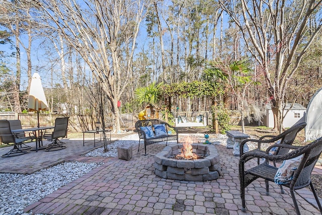 view of patio / terrace featuring fence and a fire pit