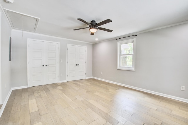 1052 Yorktown Dr, Charleston, SC 29412 - unfurnished bedroom featuring attic access, two closets, light wood-style floors, ornamental molding, and ceiling fan