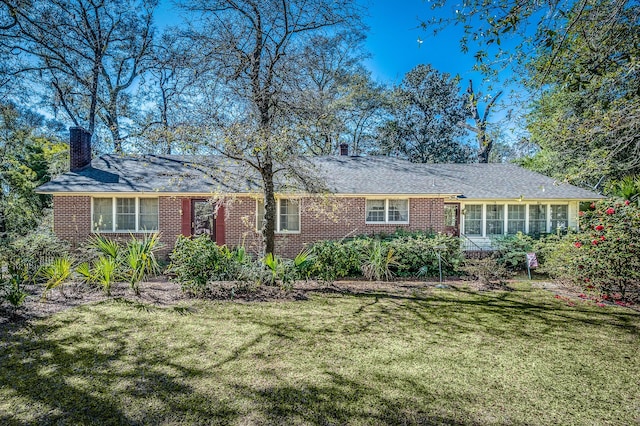 single story home with a front lawn, brick siding, and a chimney