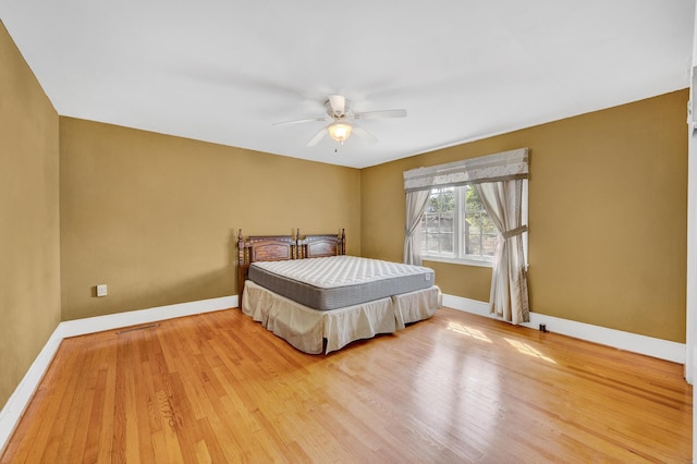 bedroom featuring baseboards, a ceiling fan, and wood finished floors