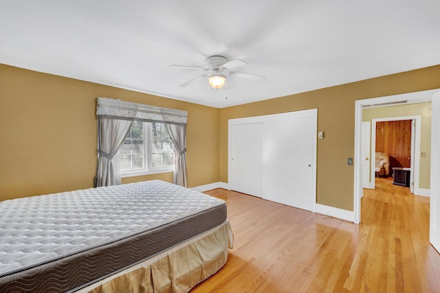 bedroom featuring baseboards, a closet, a ceiling fan, and light wood-style floors
