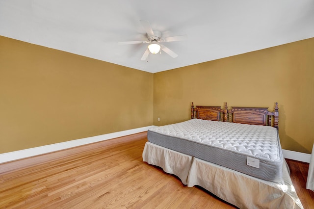 bedroom with light wood-style flooring, baseboards, and a ceiling fan