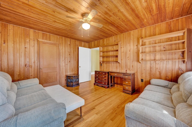 living room featuring a ceiling fan, wood walls, wood ceiling, and wood finished floors