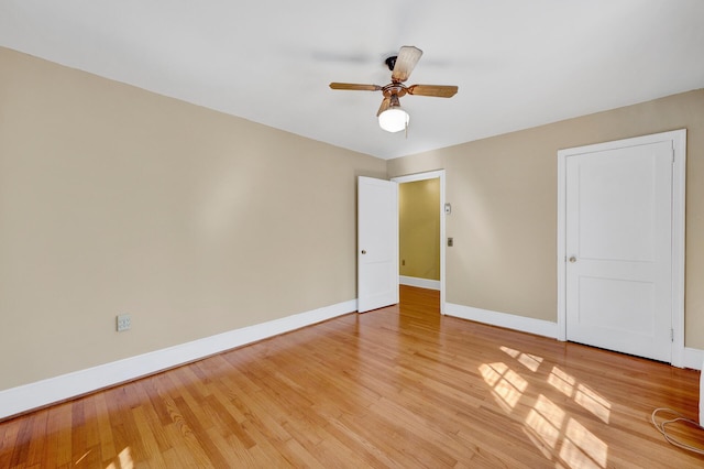 unfurnished bedroom featuring baseboards, light wood finished floors, and a ceiling fan
