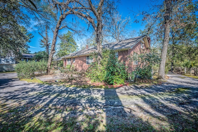 view of side of home with brick siding and a chimney