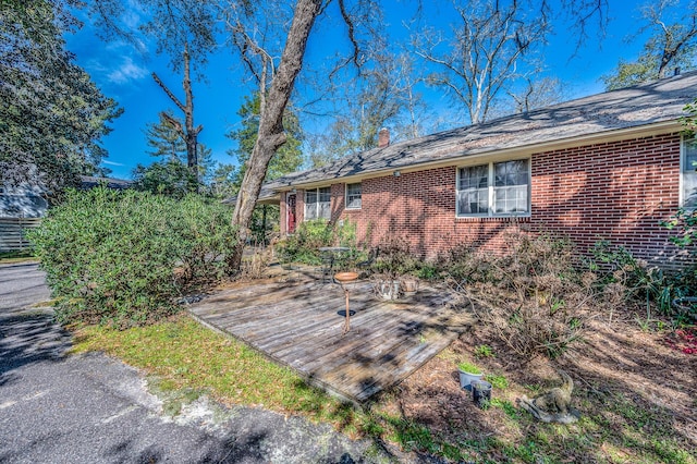 view of home's exterior featuring a chimney and brick siding