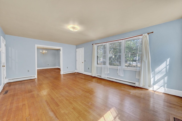 interior space with an inviting chandelier, wood finished floors, a baseboard radiator, and a baseboard heating unit