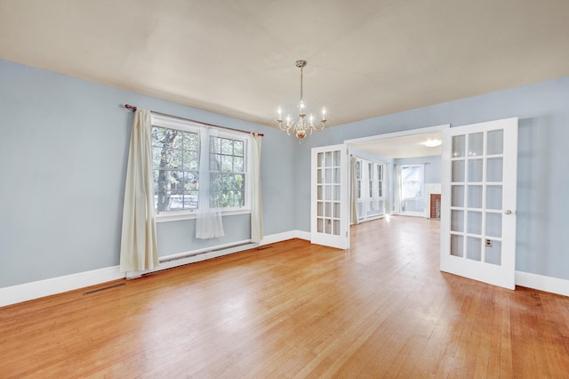unfurnished dining area with a baseboard radiator, french doors, baseboards, an inviting chandelier, and wood finished floors