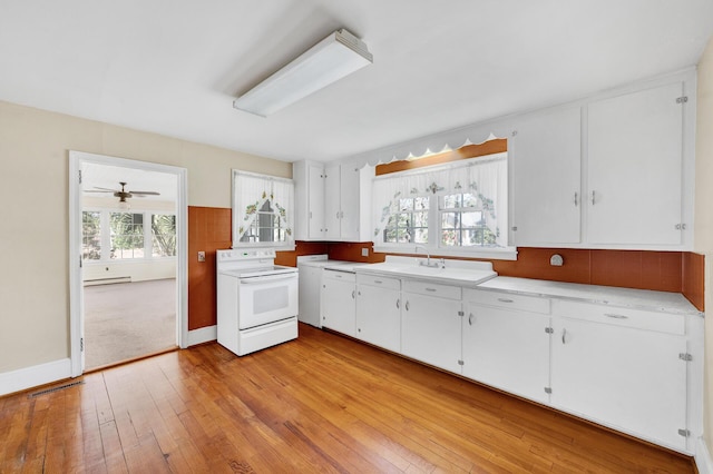 kitchen featuring a sink, white cabinetry, electric stove, light countertops, and light wood-type flooring