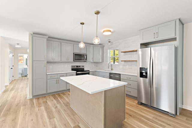 kitchen featuring sink, a kitchen island, light hardwood / wood-style floors, and appliances with stainless steel finishes