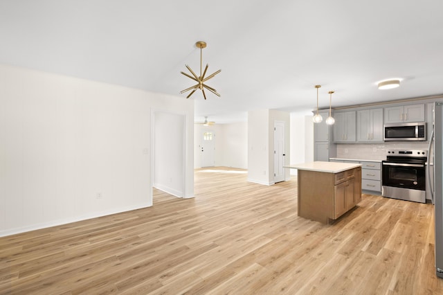 kitchen featuring gray cabinetry, a center island, hanging light fixtures, light hardwood / wood-style flooring, and appliances with stainless steel finishes