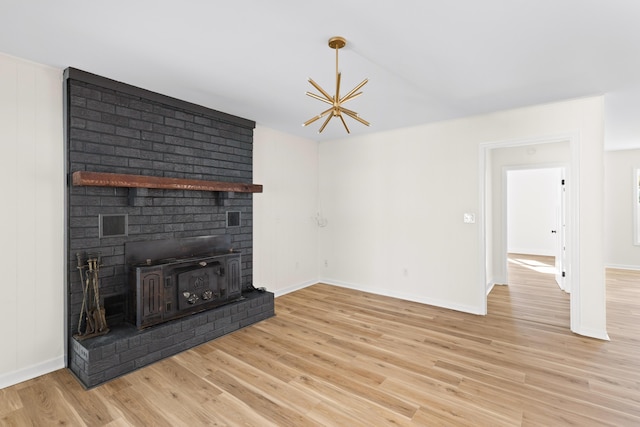 unfurnished living room with light wood-type flooring and an inviting chandelier