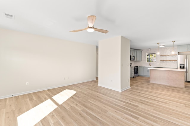 unfurnished living room with ceiling fan and light hardwood / wood-style floors