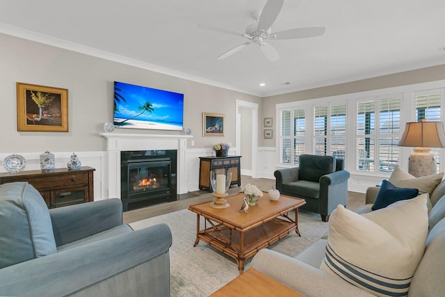 living room featuring crown molding, ceiling fan, and light wood-type flooring