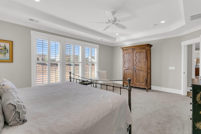 bedroom with light carpet, a raised ceiling, and ceiling fan