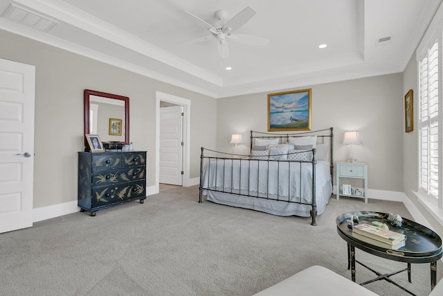 bedroom featuring ceiling fan, ornamental molding, a tray ceiling, and carpet