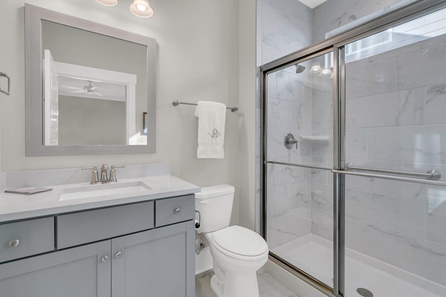 bathroom with a shower with door, vanity, ceiling fan, and toilet