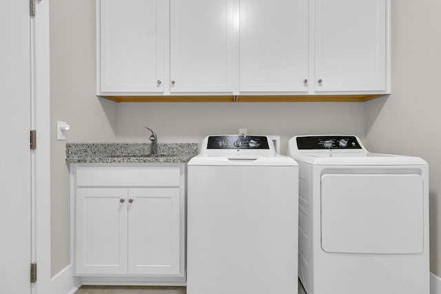 laundry area featuring sink, cabinets, and washing machine and clothes dryer