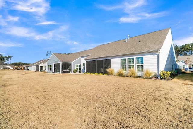 back of property with a yard and a sunroom