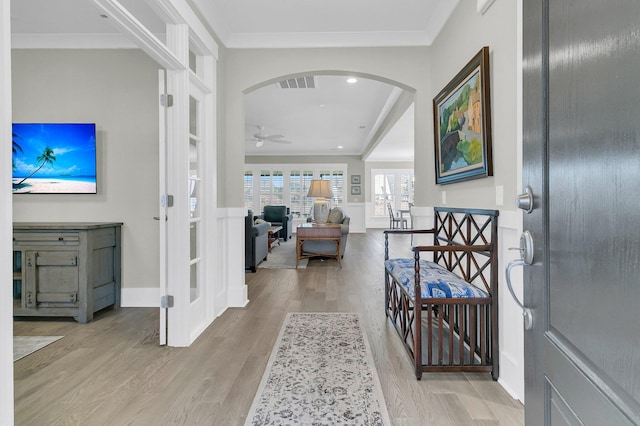 entryway with ornamental molding, ceiling fan, and light hardwood / wood-style floors