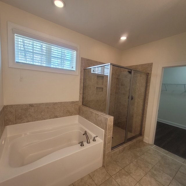 bathroom with tile patterned flooring, recessed lighting, a spacious closet, a shower stall, and a bath