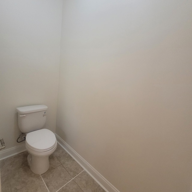 bathroom featuring tile patterned floors, toilet, and baseboards