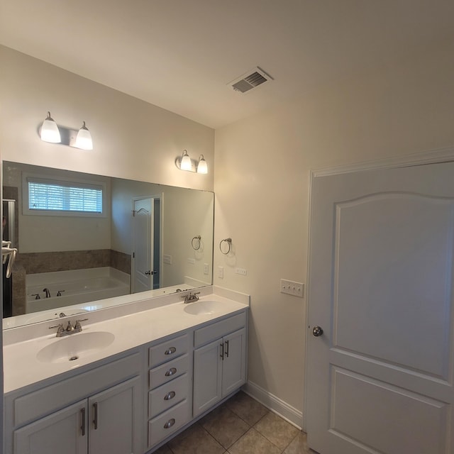 full bathroom featuring visible vents, a sink, a garden tub, and tile patterned floors