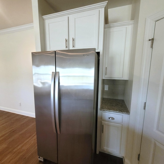 kitchen featuring tasteful backsplash, white cabinets, dark wood finished floors, and freestanding refrigerator