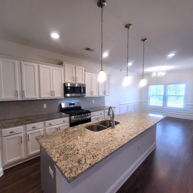 kitchen featuring white cabinets, visible vents, stainless steel appliances, and a sink