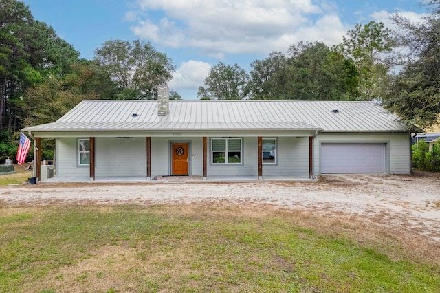 single story home featuring covered porch, a garage, and a front yard