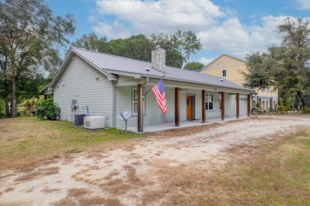 view of front of home featuring a front lawn, central AC unit, and a porch