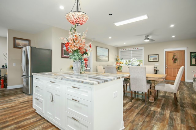 kitchen with ceiling fan, decorative light fixtures, dark hardwood / wood-style floors, white cabinetry, and stainless steel refrigerator