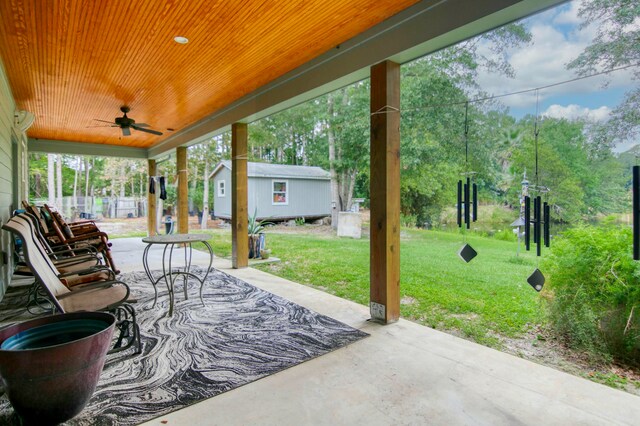 view of patio featuring ceiling fan and an outbuilding