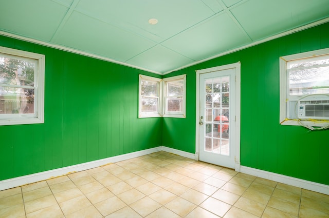 tiled empty room with cooling unit and crown molding