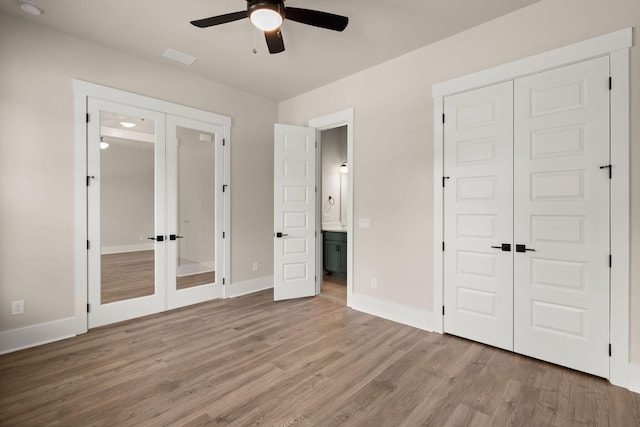 1577 Periwinkle Dr, Mount Pleasant, SC 29466 - unfurnished bedroom featuring french doors, wood finished floors, ensuite bathroom, baseboards, and a closet