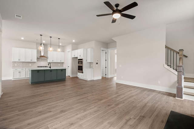 1577 Periwinkle Dr, Mount Pleasant, SC 29466 - unfurnished living room with recessed lighting, a ceiling fan, baseboards, light wood-type flooring, and a sink