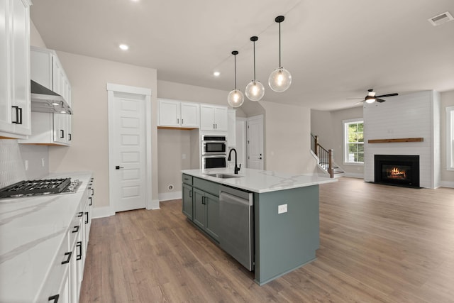 1577 Periwinkle Dr, Mount Pleasant, SC 29466 - kitchen with stainless steel appliances, extractor fan, white cabinets, a sink, and light wood-style flooring