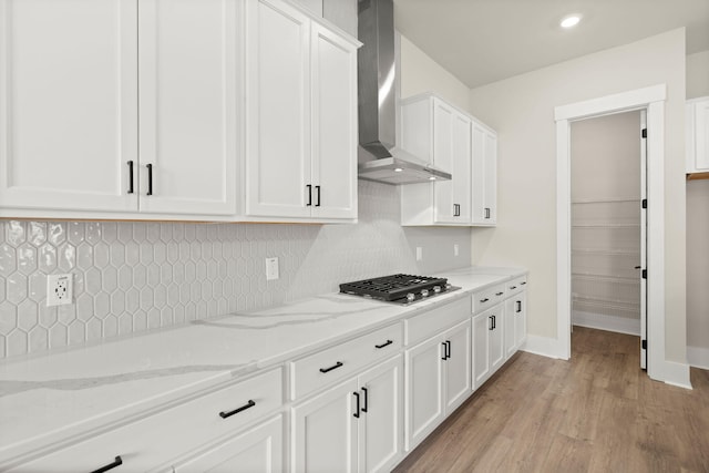 1577 Periwinkle Dr, Mount Pleasant, SC 29466 - kitchen featuring wall chimney exhaust hood, stainless steel gas stovetop, light wood-style flooring, white cabinets, and decorative backsplash