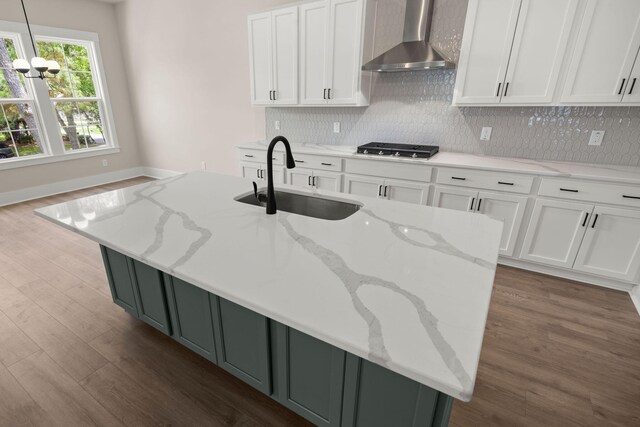 1577 Periwinkle Dr, Mount Pleasant, SC 29466 - kitchen with wall chimney range hood, a sink, stainless steel gas stovetop, wood finished floors, and white cabinets