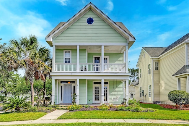 view of front facade featuring covered porch, a balcony, and a front yard