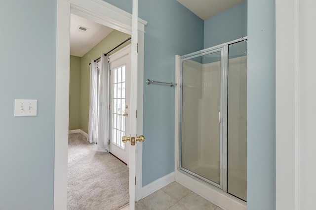 bathroom with a shower stall and baseboards