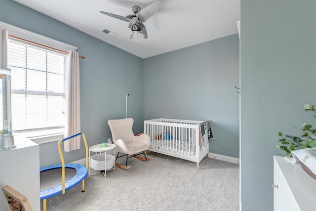 bedroom featuring carpet flooring, baseboards, a ceiling fan, and a nursery area