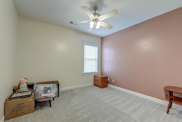 living area with a ceiling fan, baseboards, and carpet